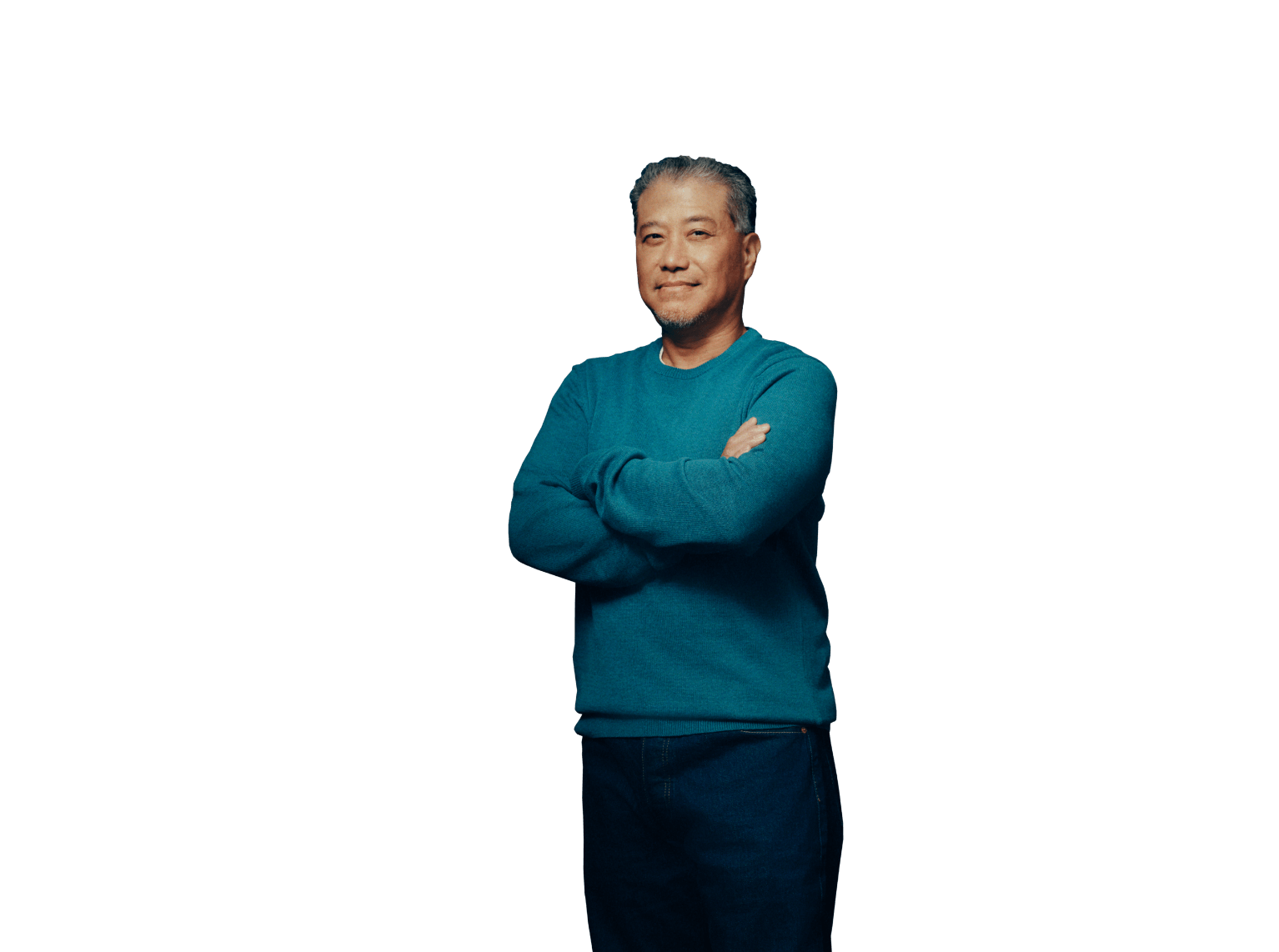 Middle aged man smiling at camera with arms folded across chest.
